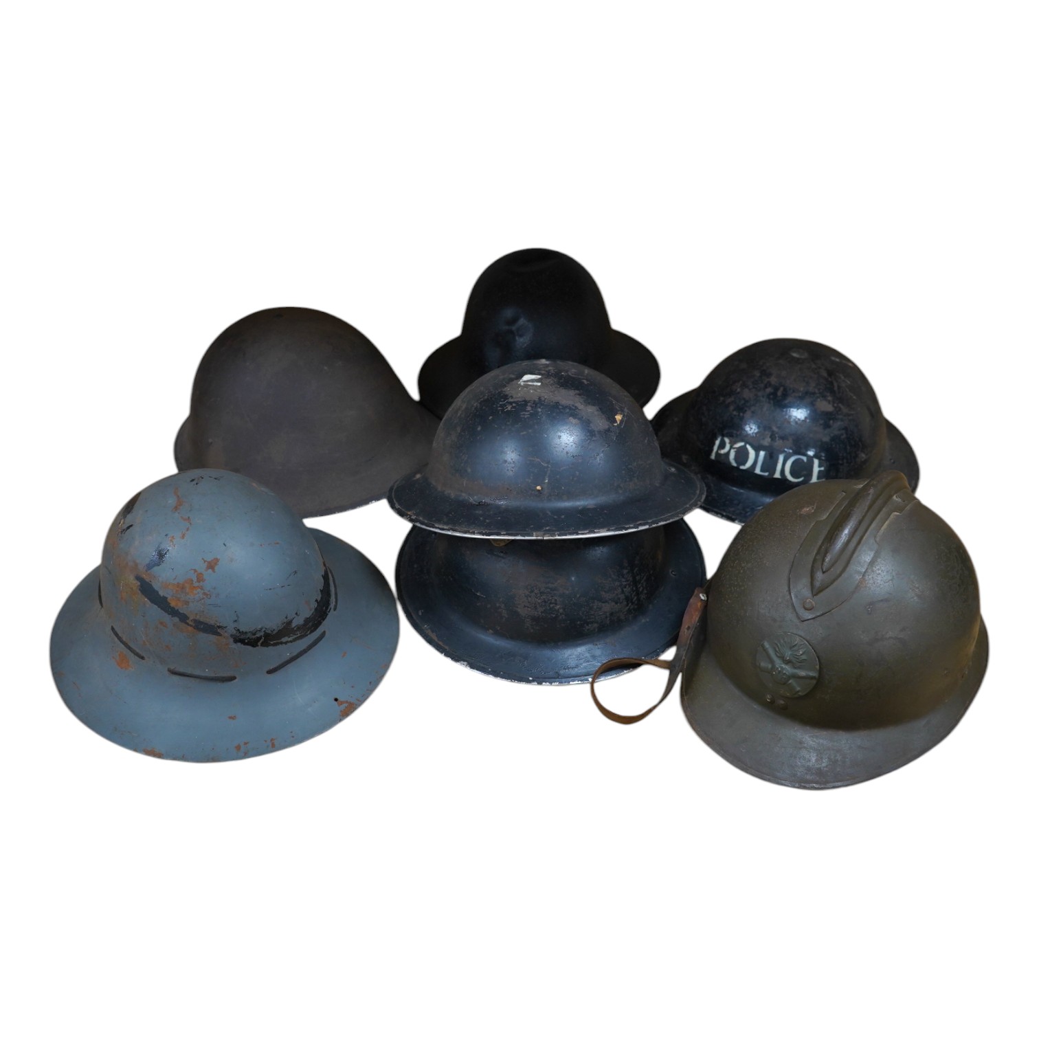 Seven early to mid 20th century military tin helmets; including one stencilled with POLICE. Condition - poor to fair.